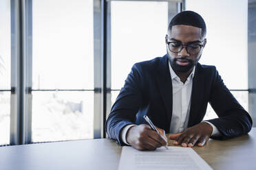 Unterzeichnung eines Hausvertrags durch einen Kunden mit einem Stift im Büro - EBBF05518