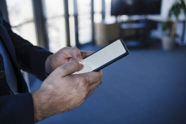 Geschäftsmann benutzt Mobiltelefon im Büro - EBBF05575