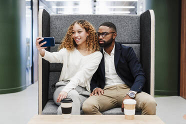 Business-Kollegen nehmen Selfie sitzen auf Sitz bei Kaffeepause in Coworking Büro - EBBF05604