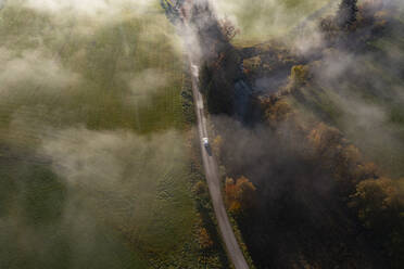 Drone Ansicht der Landschaft Feldweg entlang des Flusses an nebligen Herbstmorgen strecken - WWF06078