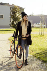 Junge Frau auf dem Fahrrad im Park - GIOF14850