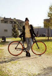 Glückliche Frau mit Fahrrad im Park - GIOF14852