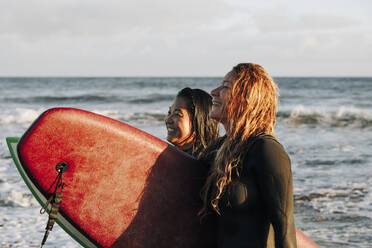 Glückliche Frauen mit Surfbrettern am Strand, Gran Canaria, Kanarische Inseln - MRRF01898