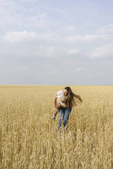 Junge Mutter spielt mit ihrem Sohn in einem Weizenfeld - SEAF00491