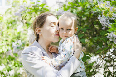 Mother with eyes closed embracing son in garden - SEAF00492