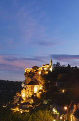 France, Lot, Rocamadour, Illuminated cliffside town at dusk - GWF07317