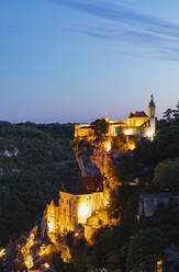 France, Lot, Rocamadour, Illuminated cliffside town at dusk - GWF07326