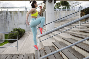 Engagierte Sportlerin läuft auf einer Treppe im Park - JCCMF05265
