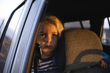 Thoughtful boy traveling in car on road trip - ASGF02123