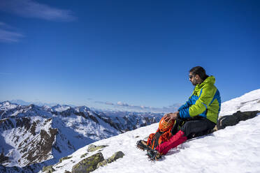 Man resting on snowy mountain at Orobic Alps in Valtellina, Italy - MCVF00951