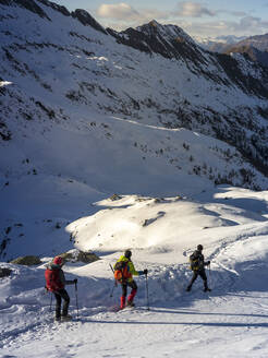 Skitourengeher, die einander auf einer verschneiten Piste in den Orobischen Alpen in Valtellina, Italien, folgen - MCVF00952