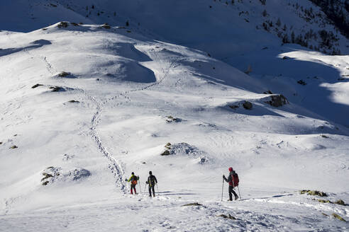 Skitourengeher beim Abstieg von einem verschneiten Berg in den Orobischen Alpen in Valtellina, Italien - MCVF00953