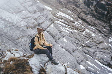 Woman sitting on mountain at Caucasus Nature Reserve in Sochi, Russia - OMIF00597