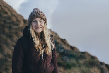 Smiling young tourist in knit hat at Caucasus Nature Reserve in Sochi, Russia - OMIF00599