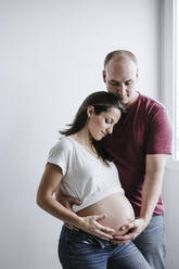 Pregnant woman standing by man at home - EBBF05667