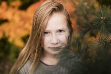 Blond girl standing near plants at autumn park - ANF00008