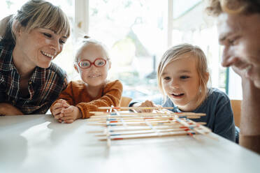 Eltern spielen Mikado mit ihren Kindern zu Hause - JOSEF07046