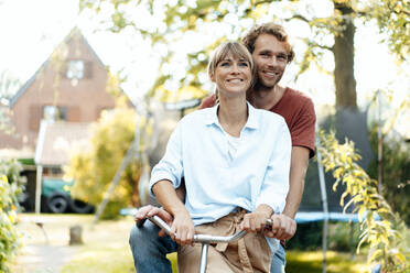 Smiling man with woman riding bicycle - JOSEF07049