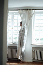 Frau bedeckt mit weißem Vorhang zu Hause - JOSEF07069
