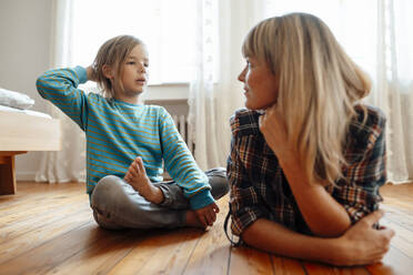 Son talking to mother lying on floor at home - JOSEF07091