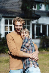 Lächelnder Mann und Frau umarmen sich im Garten - JOSEF07103