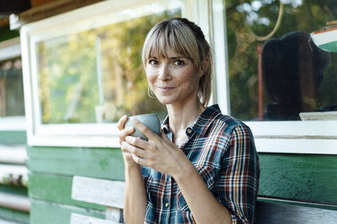 Woman having coffee in garden - JOSEF07108