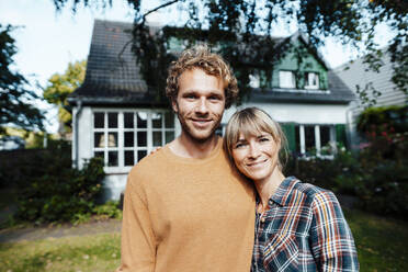 Smiling man and woman outside house - JOSEF07131