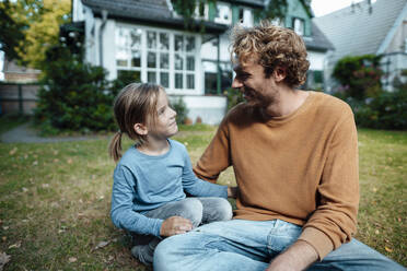 Smiling son and father in garden outside house - JOSEF07146