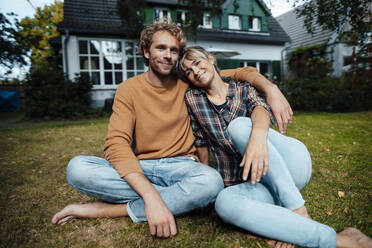 Couple sitting together on ground in garden - JOSEF07151