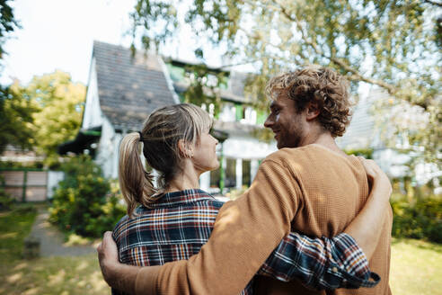 Man and woman looking at each other in garden - JOSEF07156