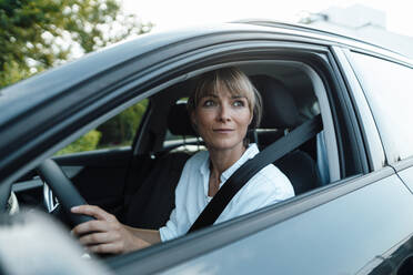 Nachdenkliche Frau am Steuer eines Autos auf einer Autoreise - JOSEF07167