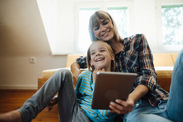 Mother and son with tablet PC laughing at home - JOSEF07182