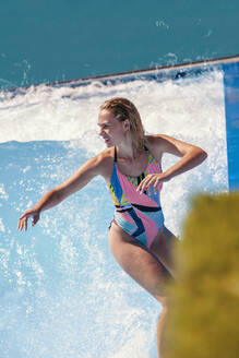 Entschlossener Surfer beim Surfen im Schwimmbad - MRRF01936