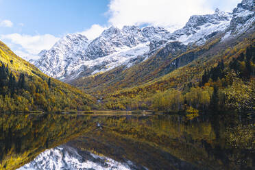 Schneebedeckte Berge, die sich im Herbst in einem See spiegeln, Naturschutzgebiet Kaukasus, Sotschi, Russland - OMIF00606