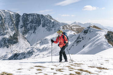Glückliche Frau beim Wandern auf einem schneebedeckten Berg, Naturschutzgebiet Kaukasus, Sotschi, Russland - OMIF00611