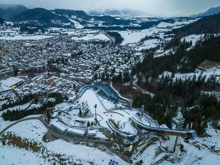 Deutschland, Bayern, Oberstdorf, Hubschrauberansicht der verschneiten Stadt in den Allgäuer Alpen mit Skisprungschanze im Vordergrund - AMF09388