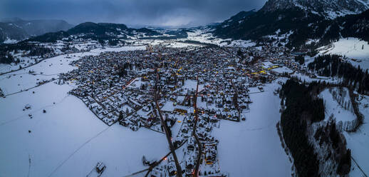 Germany, Bavaria, Oberstdorf, Helicopter panorama of snow covered town in Allgau Alps at dusk - AMF09394