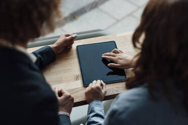 Geschäftsfrau benutzt Tablet-PC von Geschäftsmann in Coworking-Büro - GUSF06800