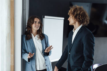 Young businesswoman discussing strategy with colleague in office - GUSF06809