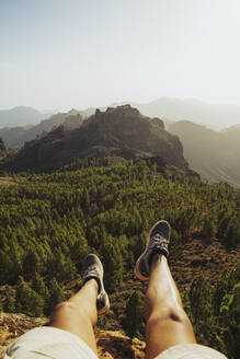 Mann sitzend auf einem Berg am Roque Nublo, Großkanarische Inseln, Spanien - RSGF00861