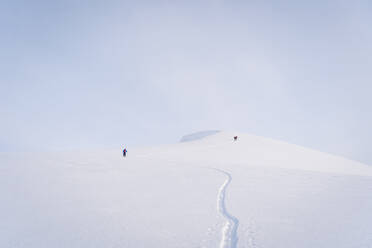 Happy woman sliding down slope covered with snow while happy