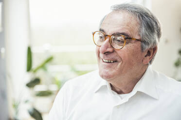 Smiling senior man wearing eyeglasses at home - UUF25332