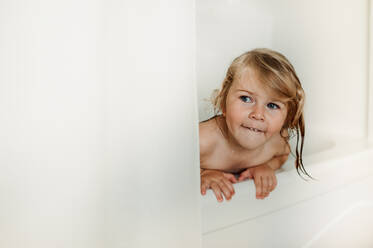 Wet girl peeking from shower curtain - ELEF00009