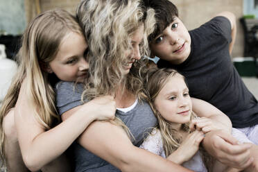 Smiling mother sitting with son and daughters - ANF00029