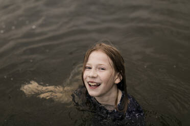 Glückliches Mädchen mit braunen Haaren spielt im Wasser - ANF00036