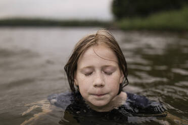 Girl with eyes closed swimming in lake - ANF00038
