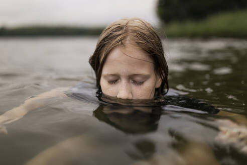 Mädchen mit geschlossenen Augen schwimmt im See - ANF00039