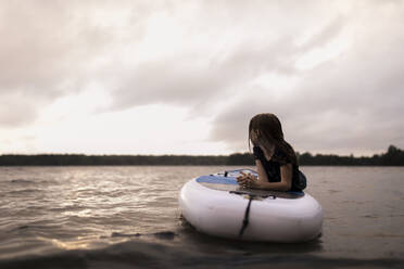 Mädchen liegend auf Paddleboard am See - ANF00043