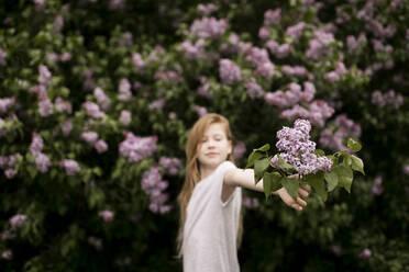 Girl holding lilac flowers in nature - ANF00060