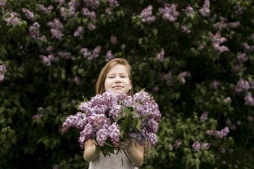 Cute girl holding fresh flowers in nature - ANF00063